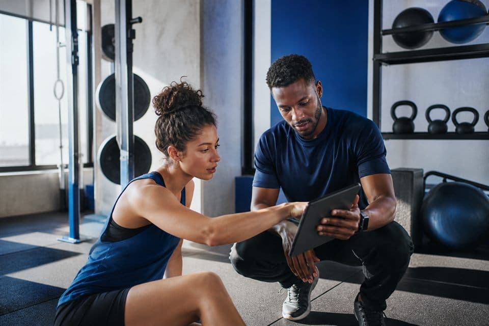 Trainer and member reviewing progress in a bright studio